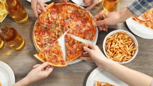 pessoas comendo pizza, tomando cerveja e comendo batata frita