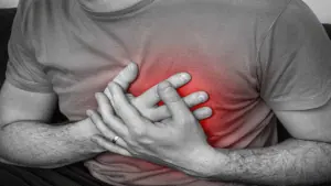 homem sentindo dores no peito, com suspeita de problemas cardiovasculares