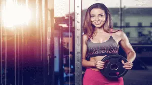 mulher com uma anilha de peso na mão praticando esporte