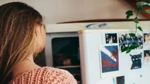 mulher olhando geladeira