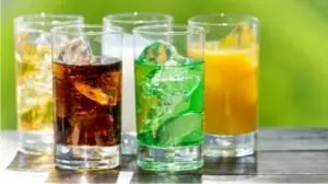 5 copos de vidro com cola, refrigerante de limão, suco de laranja e gelo