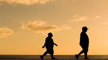 Dois homens obesos caminhando no fim de tarde