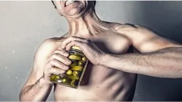 Homem sem força abrindo pote de legumes