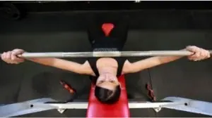 mulher concentrada levantando peso