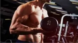 Homem forte treinando com halteres